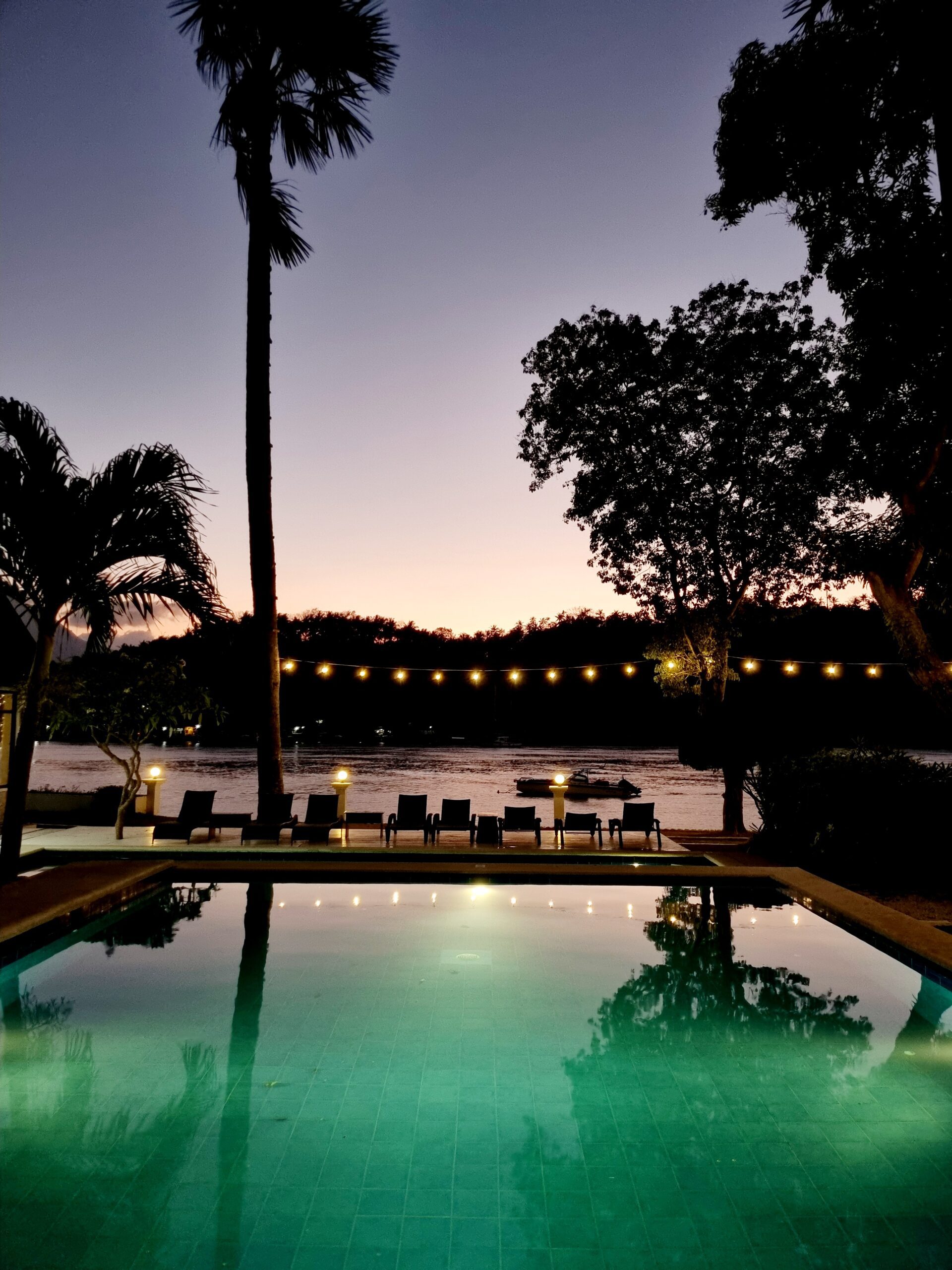 A view of the pool and beachfront at sunset at Casalay Puerto Galera