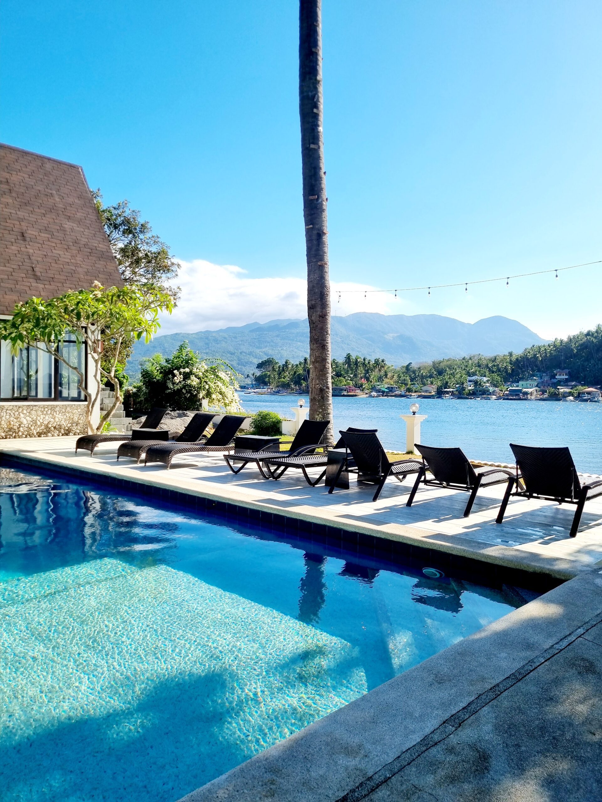 A view of the pool, sun loungers, and beach front at Casalay Puerto Galera