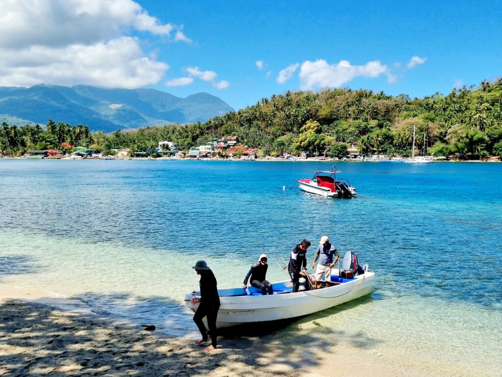 scuba divers getting out of the boat after a dive in Puerto Galera