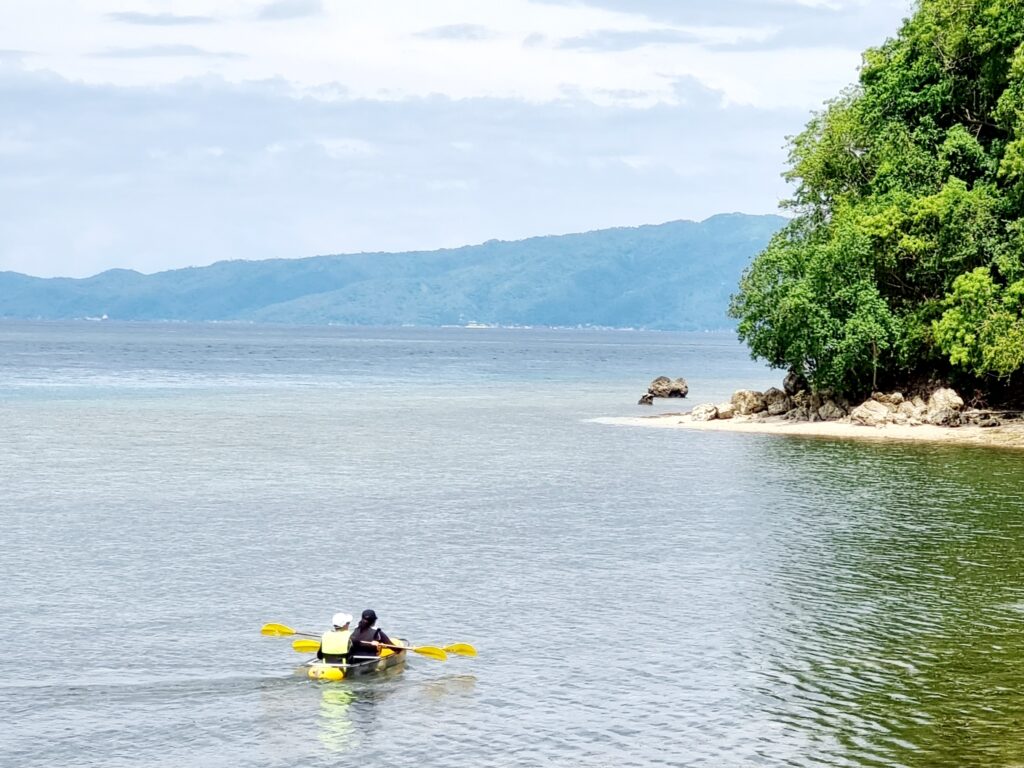 Using a crystal kayak over calm waters at Casalay Puerto Galera