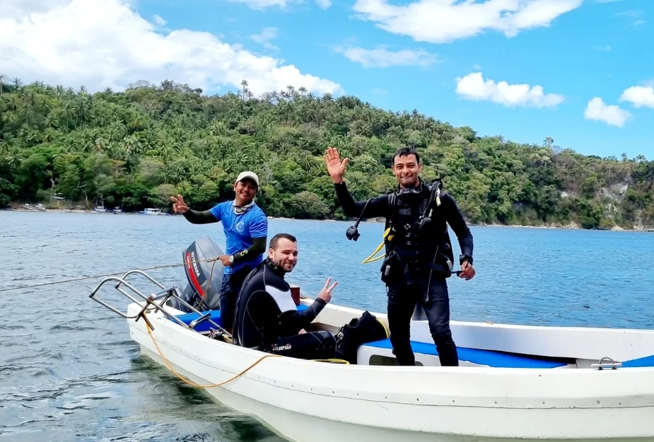 Casalay PADI instructor and student on a boat with stunning tropical scenery in Puerto Galera.