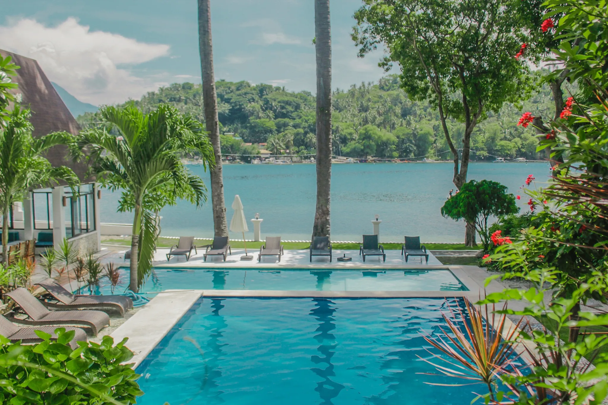 Alt A stunning poolside view overlooking the ocean, surrounded by lush tropical greenery at Casalay Boutique Villas & Dive Resort in Puerto Galera.